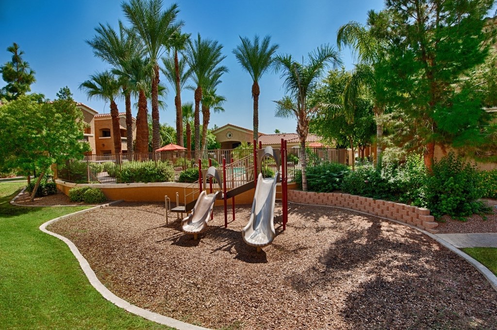 Apartments for Rent Surprise - The Village at West Point - Playground with Slides Surrounded by Lush Landscaping.