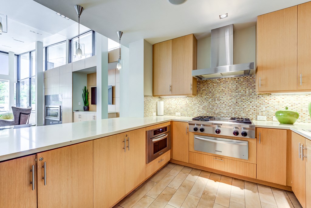 Apartments Kitchen With Wooden Cabinetry And Multi-Colored Tile Backsplash at Venue, San Francisco, CA