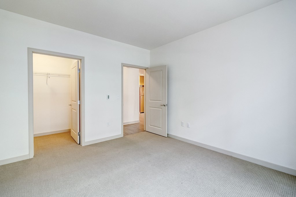 the living room and bedroom of an apartment with white walls and carpet at Venue, San Francisco, CA