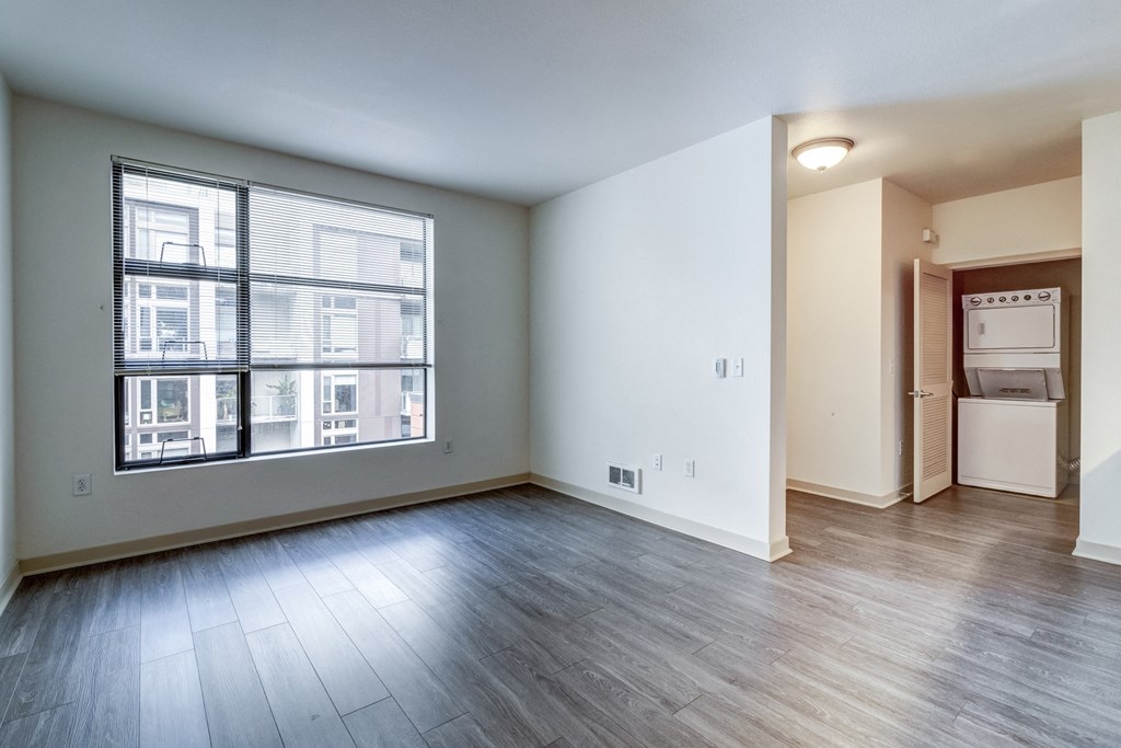 an empty living room with a large window and wood flooring at Venue, San Francisco, CA