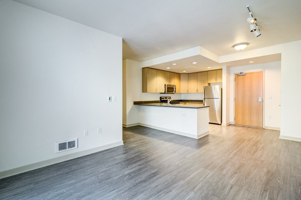 the living room and kitchen of an empty apartment with wood flooring at Venue, San Francisco, CA