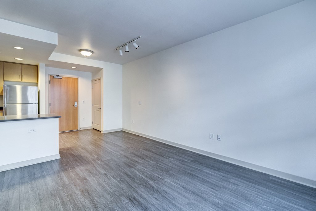 the living room and kitchen of an apartment with wood floors and white walls at Venue, San Francisco, 94158