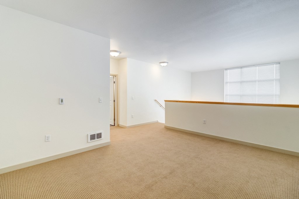 the living room and dining room of an apartment with carpeting and a window at Venue, San Francisco, CA