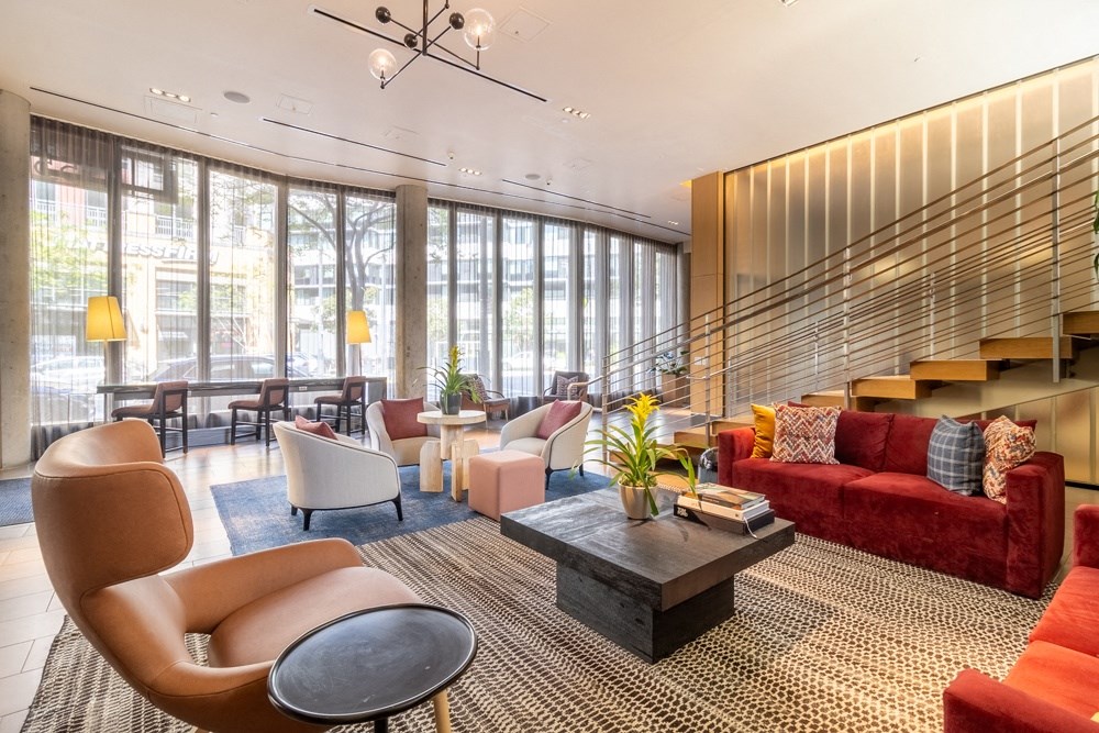 A living room with a red couch and a brown chair.