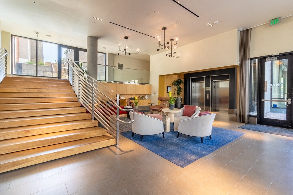 A spacious living room with a staircase and a dining table.
