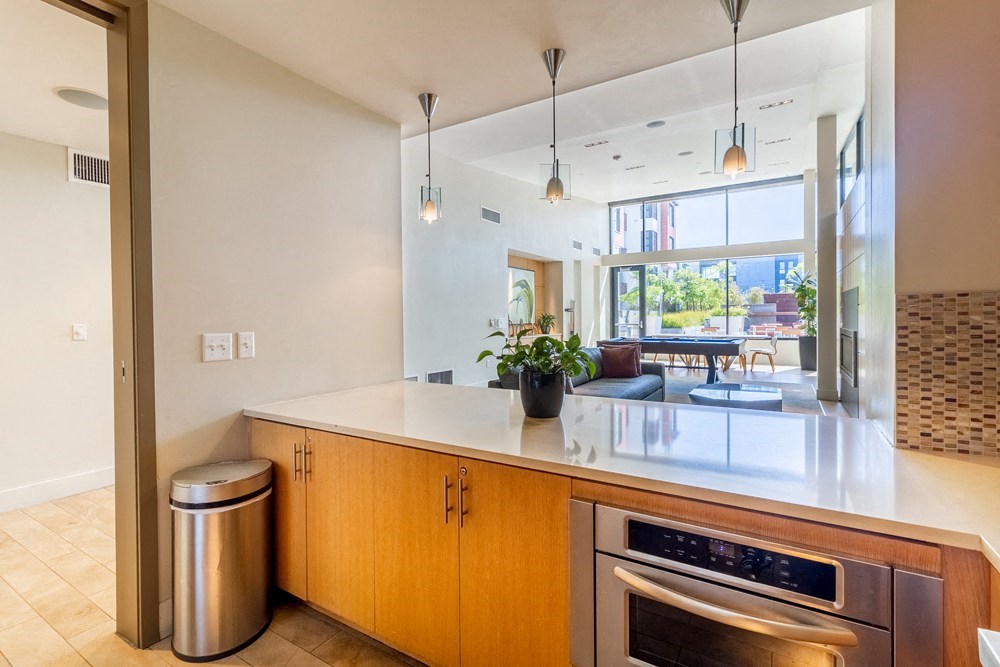A modern kitchen with wooden cabinets and a stainless steel oven.