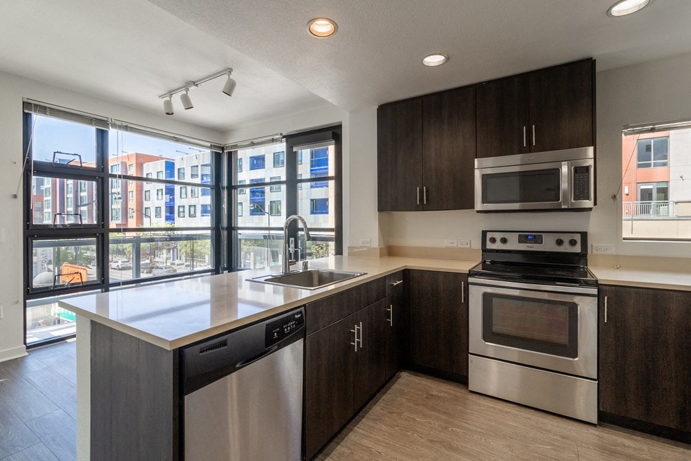 A modern kitchen with dark wood cabinets and stainless steel appliances.