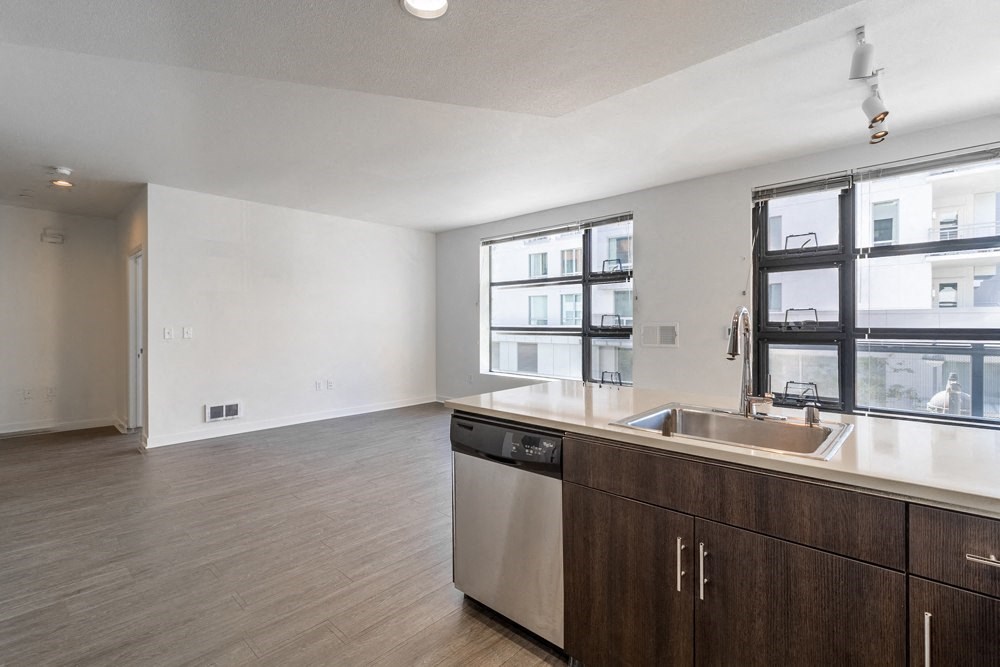 A kitchen with a dishwasher and wooden cabinets.