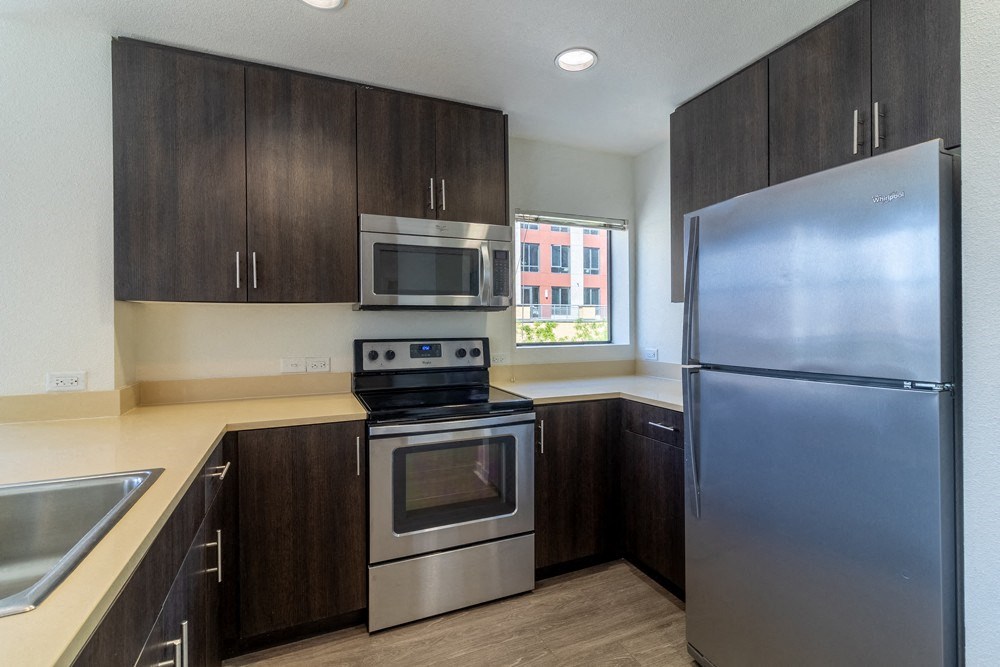 A kitchen with a stainless steel refrigerator, oven, and microwave.