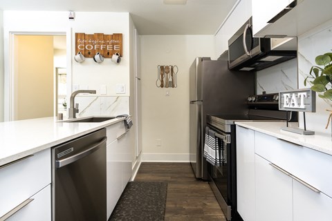 a kitchen with white cabinets and a stainless steel refrigerator