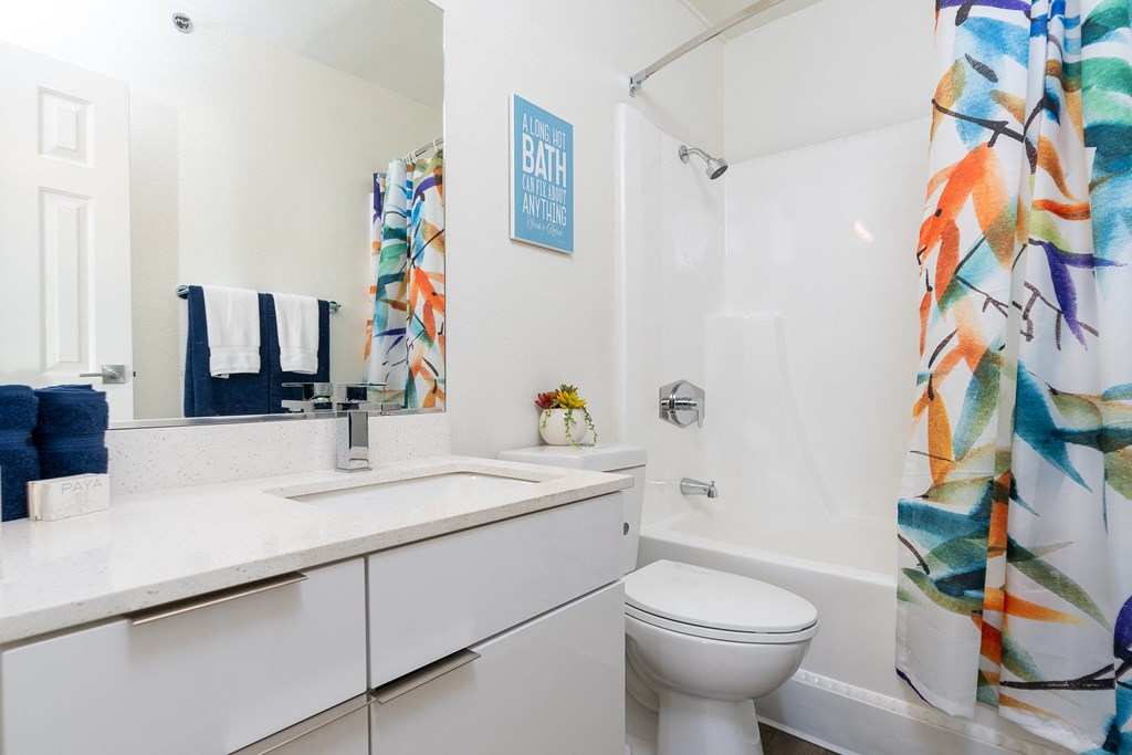 a bathroom with a shower curtain and a sink and a toilet