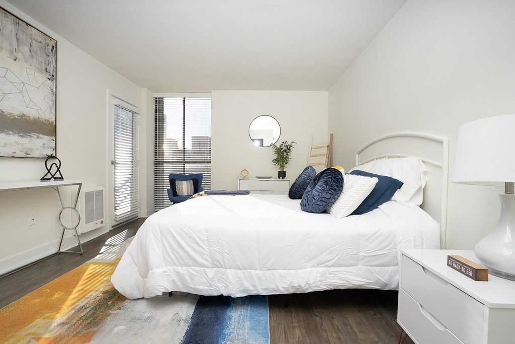 Bedroom with white bed, white night stand and light artwork  on the wall