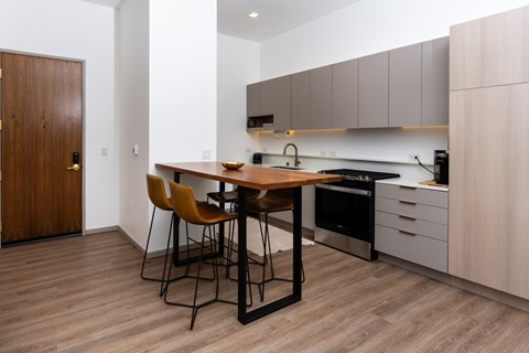 A modern kitchen with a wooden table and chairs.