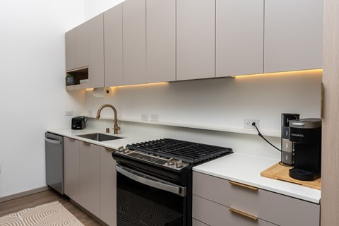 A modern kitchen with a black stove top oven and a white counter top.