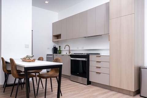 A modern kitchen with a dining table and chairs.