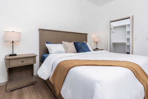 A bedroom with a bed, nightstand, and lamp.