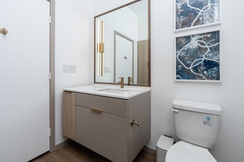 A bathroom with a toilet, sink and photos on the wall
