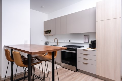 A kitchen with a table and chairs.