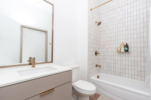 A white bathroom with a toilet, sink, and bathtub.