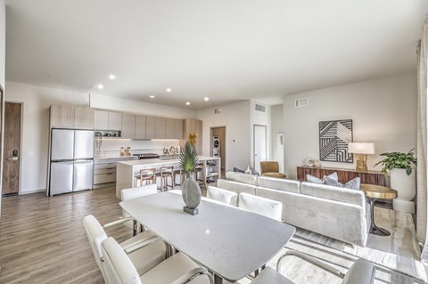 a living room and kitchen with white furniture and a white table
