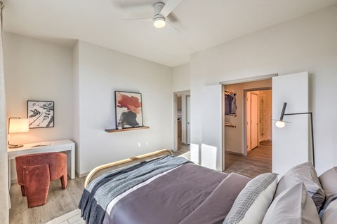 a bedroom with a bed and a desk and a hallway