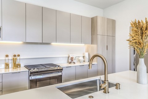 a modern kitchen with stainless steel appliances and white counter tops
