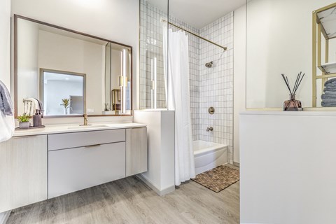 A white bathroom with a large mirror and a walk-in shower.