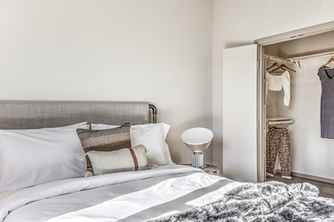 a bedroom with a bed and an open closet