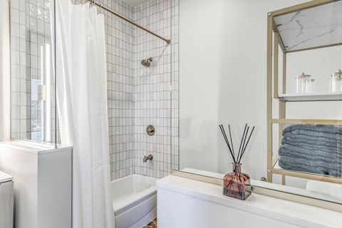 a white bathroom with a shower and a white tub
