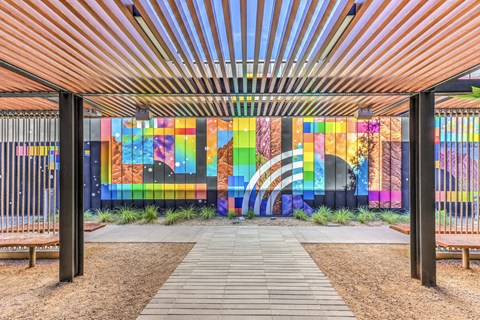 a colorful mural on the side of a building with benches