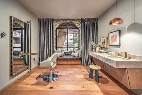 A bathroom with a large mirror, a chair, and a vanity with a sink.