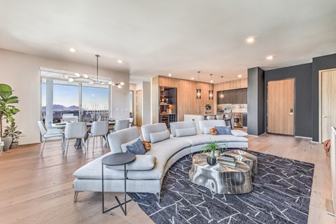 A modern living room with a curved sofa and a coffee table in the center.