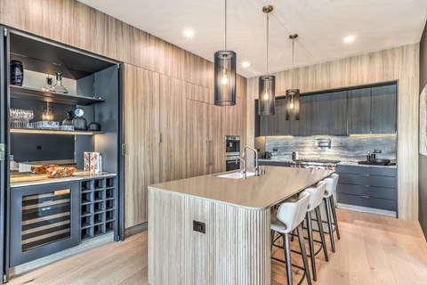 A modern kitchen with a wooden wall and a central island.