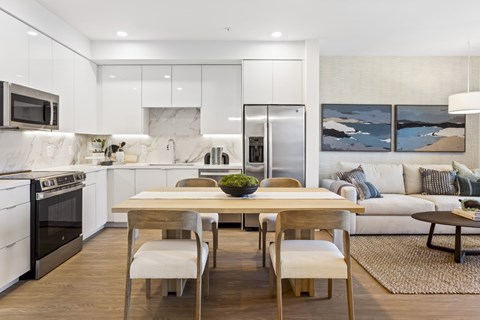 A modern kitchen with a dining table and chairs.