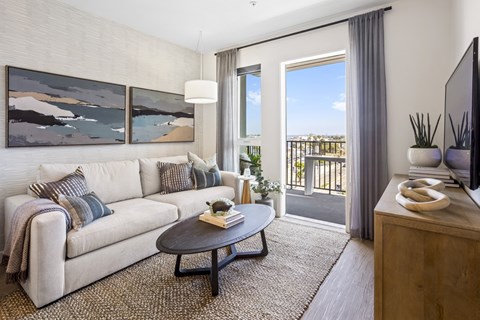 A living room with a white couch, a coffee table, and a painting on the wall.