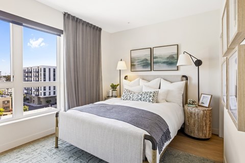 A bedroom with a large bed and a view of the city.