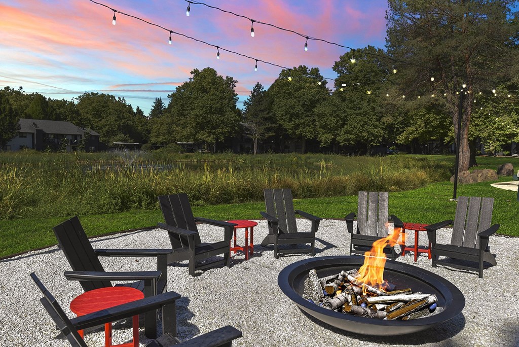 Firepit with lounge seating at dusk at Woodlake Apartments, Kirkland, WA