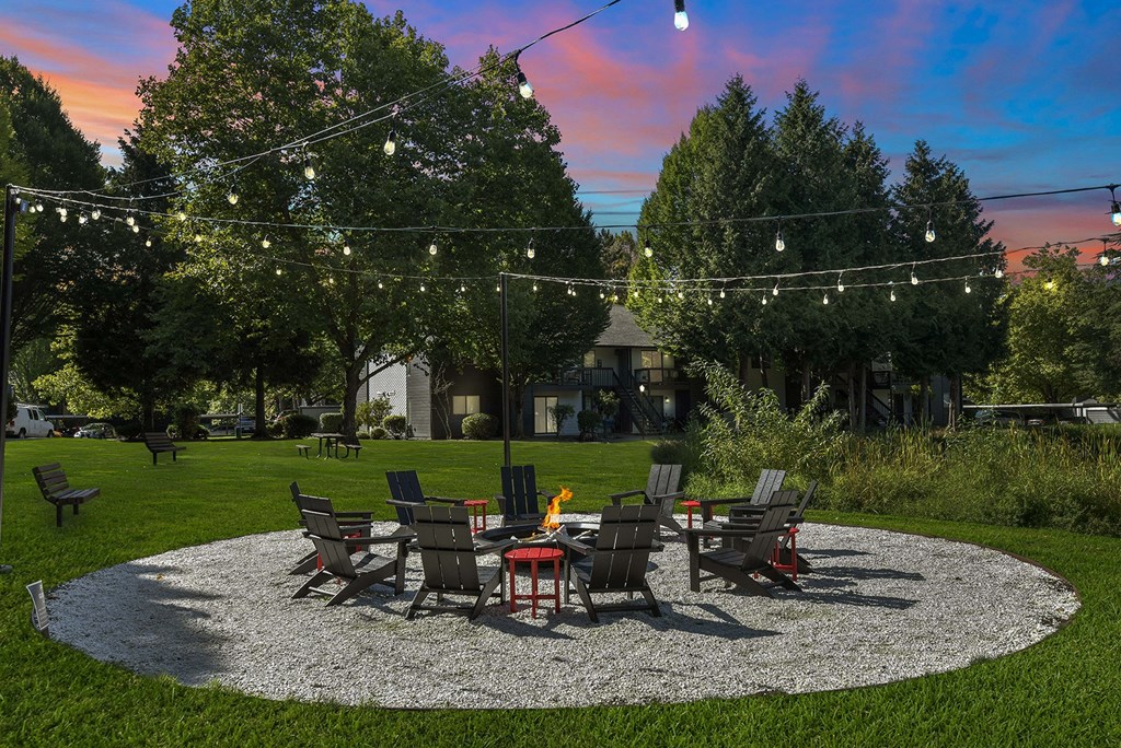 Firepit with lounge seating at dusk at Woodlake Apartments, Kirkland 98034
