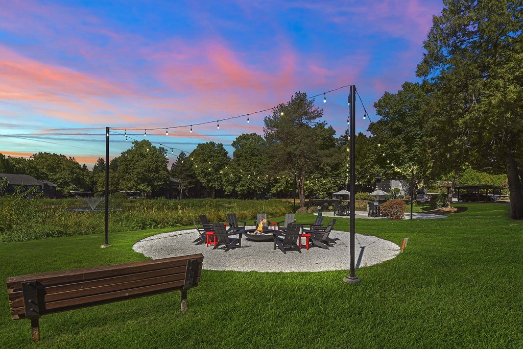 Firepit with lounge seating at dusk at Woodlake Apartments, Kirkland, Washington