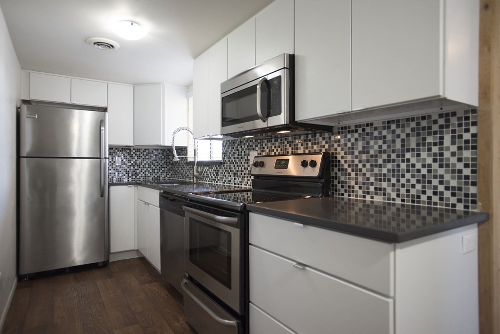 1-Bedroom Apartments in Scottsdale, AZ - Winfield Scottsdale - Modern and Stylish Kitchen Interior Showcasing Stainless Steel Appliances and Mosaic Backsplash.