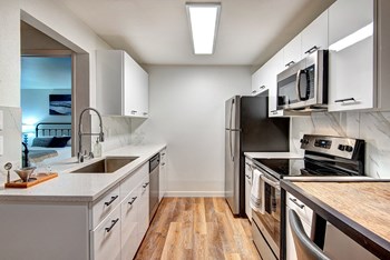 Kirkland WA Apartments for Rent - Woodlake - Modern Kitchen with White Cabinets, Stainless Steel Appliances, and Wood Flooring - Photo Gallery 3