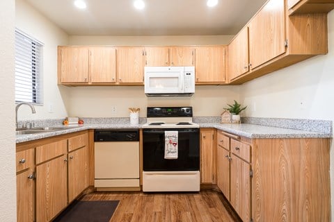 a kitchen with wooden cabinets and white appliances and granite counter tops