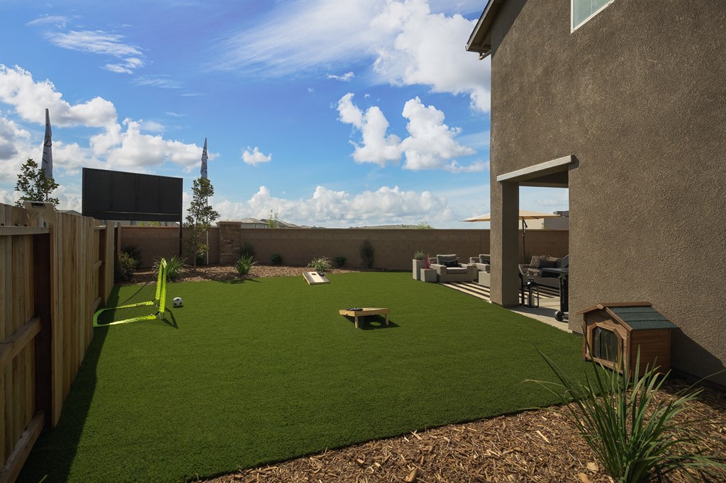 Homes in Roseville - Cyrene at Fiddyment - Backyard with Patio Furniture, Grass, Patio with BBQ, and Umbrella.