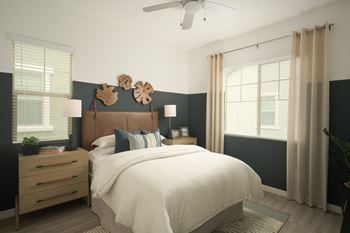 A bedroom with a large bed and a ceiling fan.