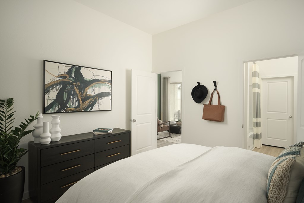 A bedroom with a large bed and a painting on the wall.