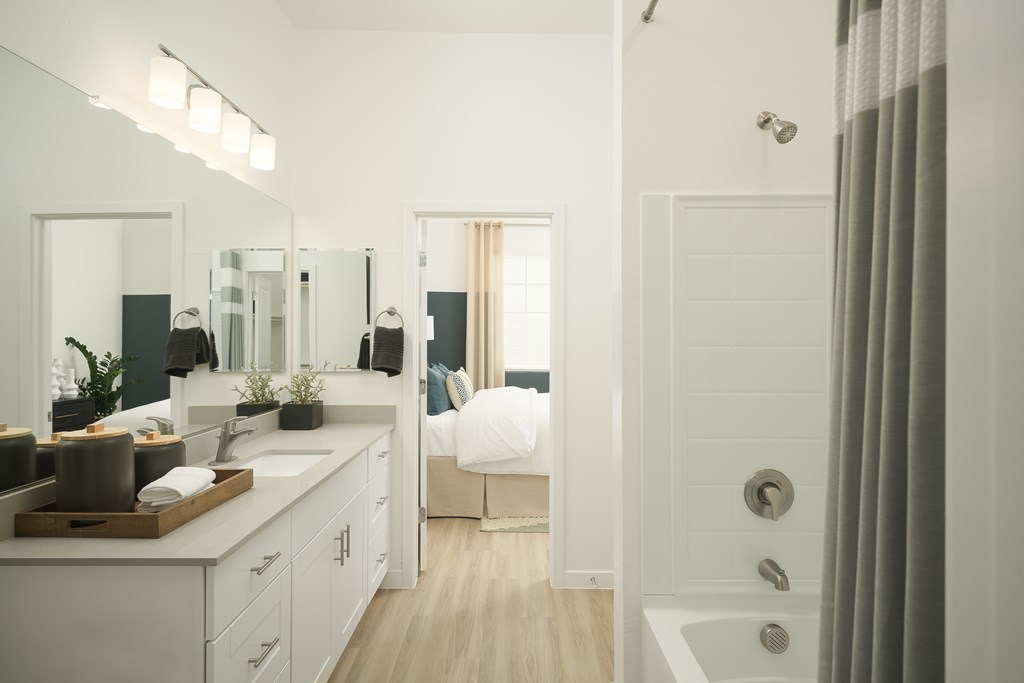 A bathroom with a white tub and sink.