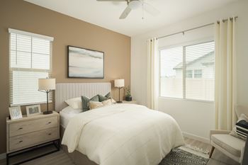 A bedroom with a bed, nightstand, and chair.