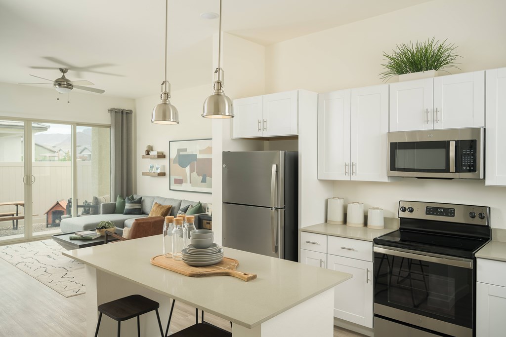 A modern kitchen with white cabinets and stainless steel appliances.