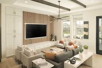 A modern living room with a grey sofa, a white coffee table, and a flat screen TV mounted on a wooden wall.