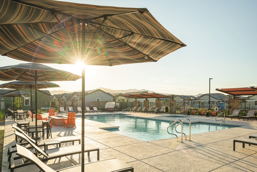 A sunny day at the pool with umbrellas providing shade.